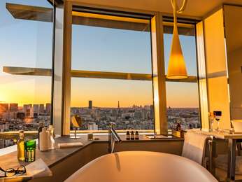 EIFFEL TOWER JUNIOR SUITE Bathrm with view of Paris at sunset 1 king bed